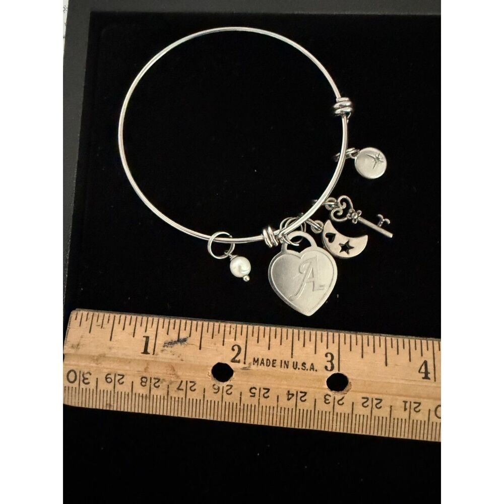 Silver tone charm bracelet with heart, moon, key and pearl charms with letter A